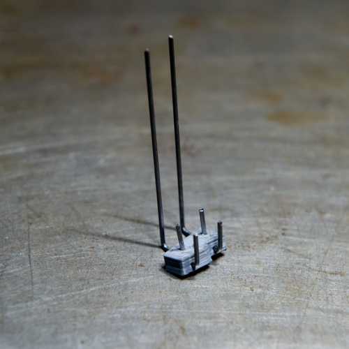 Gabarit culbuteurs photographié à l'envers. les 4 petits picots se positionnent dans les trous d'axe des ressorts de soupapes et au niveau des axes des culbuteurs.